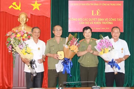 Trung tướng Nguyễn Xuân Mười trao Quyết định của Bộ trưởng Bộ Công an và của Bảo hiểm xã hội CAND cho đồng chí Trần Công Viên, Nguyễn Văn Danh, Phạm Hùng Thắng.