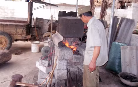 Ông Lương Văn Pờ kể chuyện rèn dao, búa bằng mắt cùng phóng viên.