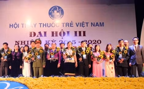 Phó Thủ tướng Vũ Đức Đam, Bộ trưởng Bộ Y tế Nguyễn Thị Kim Tiến trao hoa và biểu trưng cho 30 gương thầy thuốc trẻ bám bản tiểu biểu.