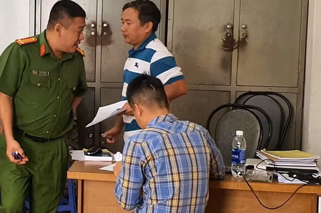 Công an đang lấy lời khai một con bạc (ngồi)