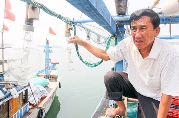 Ông Trần Sinh chỉ cho xem một số đèn chong cá bị các đối tượng trên tàu Trung Quốc bắn vỡ.