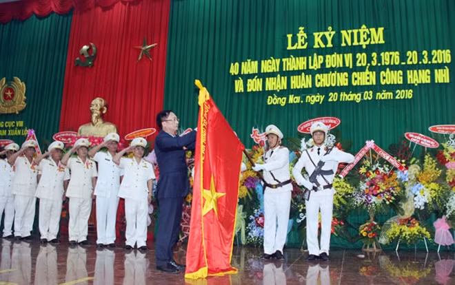 Thứ trưởng Nguyễn Văn Thành gắn Huy chương Chiến công hạng Nhì lên lá cờ truyền thống của Trại giam Xuân Lộc.