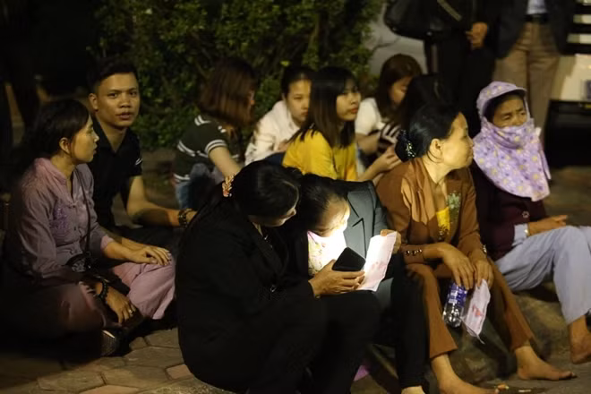 Nhiều người ngồi nói chuyện, dùng điện thoại để “ giết” thời gian