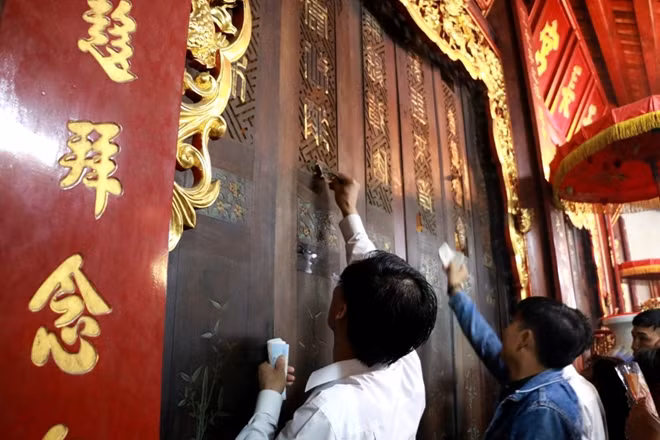 Khu vực hậu cung của đền lúc này đã bị khóa, nhưng nhiều người cố gắng gài tiền vào cửa
