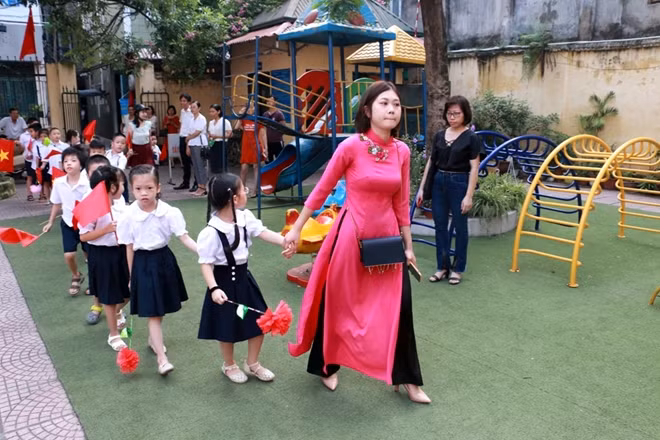 Với rất nhiều em hôm nay là ngày chính thức bước vào đời học sinh. Trong ảnh là cô trò trường PTCS Xã Đàn (Đống Đa, Hà Nội) vào ngày khai giảng.