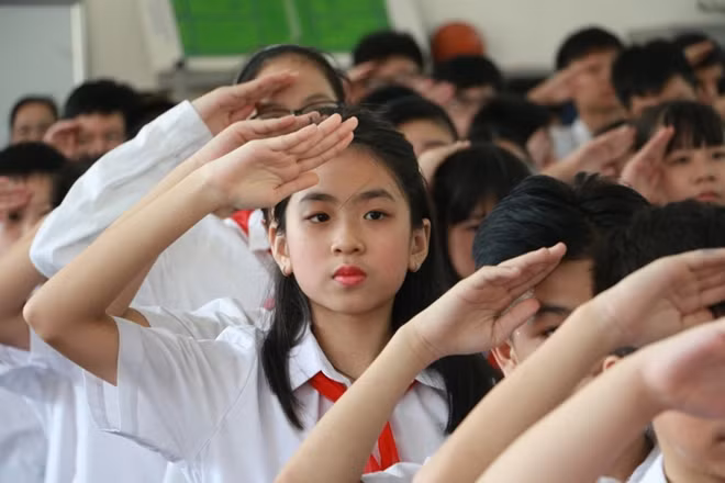 Các em học sinh trường PTCS Xã Đàn chào cờ trong lễ khai giảng.