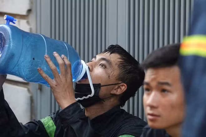 Một chiến sĩ cảnh sát uống nước trong ít phút nghỉ để có sức tiếp tục nhiệm vụ.