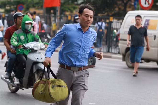 Không quá đông nhưng vì vẫn là ngày làm việc bình thường nên phải tới cuối giờ chiều nhiều người mới đổ về bến xe. Trong ảnh một vị khách đang nhanh chóng băng qua đường giải phóng để vào bến Giáp Bát kịp bắt xe về quê.