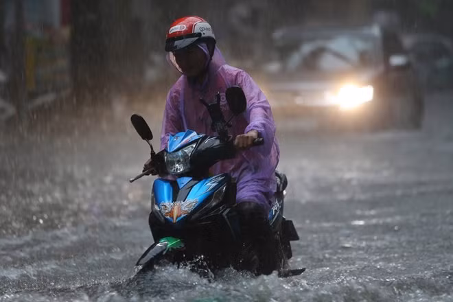 Các đường phố Hà Nội bị biến thành sông sau mưa lớn.