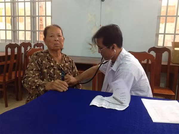 Các bác sĩ, y sỹ tận tình thăm hỏi, khám bệnh cho người dân nghèo.