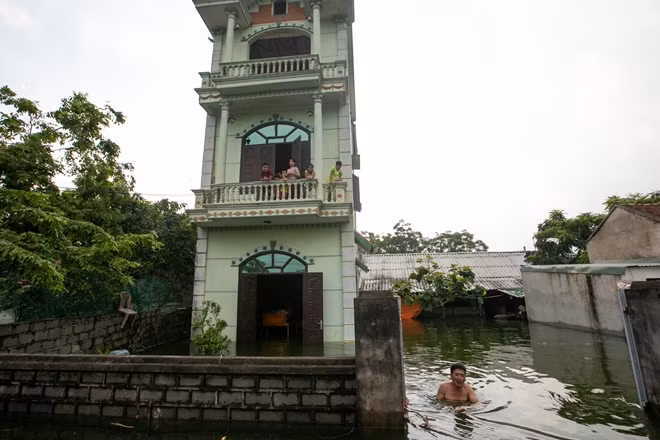 Một hộ dân ở thôn Nam Hài, xã Nam Phương Tiến, Chương Mỹ, Hà Nội. Nhà ngập gần hết tầng 1, bố mẹ cùng các con phải di dời lên tầng 2.