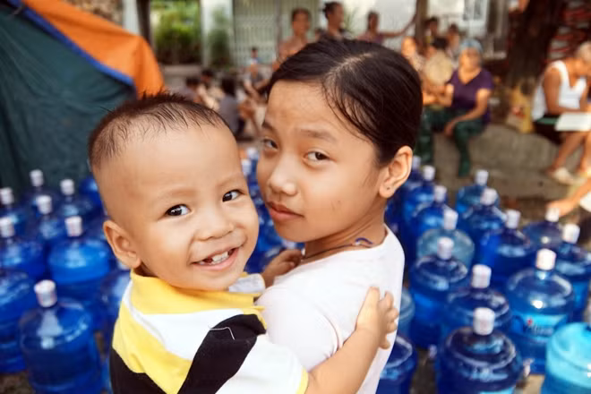 Bế em đi lấy đồ cứu trợ