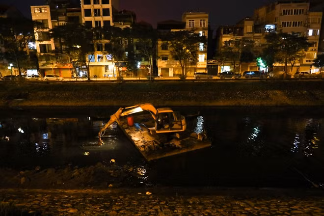 Máy xúc được "thả nổi" trên sông dùng gầu xúc bùn lên để công nhân dùng ống hút lên xe, chiếc gầu còn có nhiệm vụ như "mái chèo" giúp máy xúc di chuyển trên sông