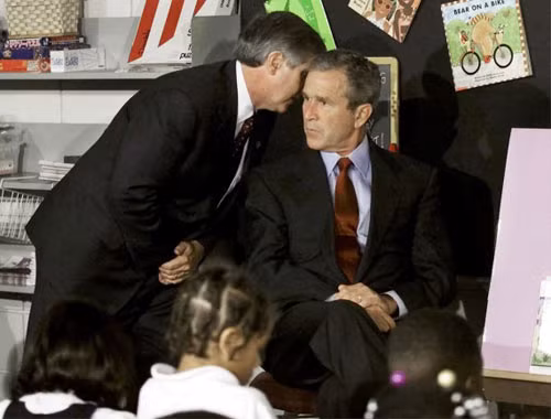 Tổng thống Mỹ George W. Bush nghe Chánh văn phòng Nhà Trắng báo cáo về chiếc máy bay thứ hai tấn công WTC, khi ông đang có mặt trường Tiểu học Emma E. Booker ở Sarasota, Florida. Ảnh: Reuters.