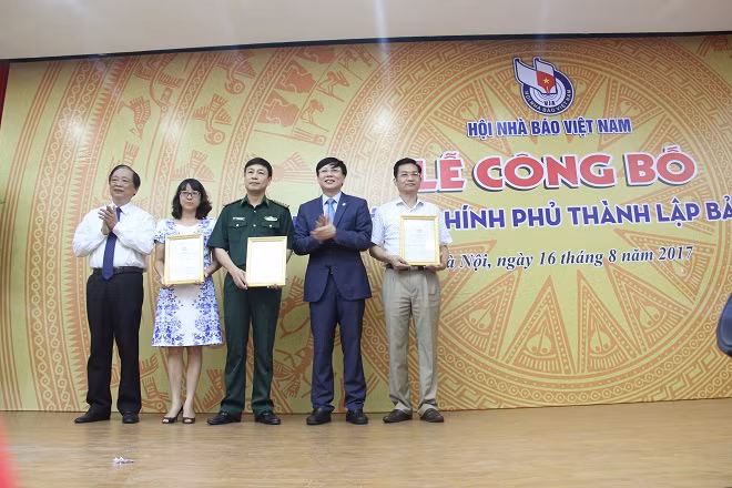 Đồng chí Hồ Quang Lợi trao giấy chứng nhận tiếp nhận hiện vật hiến tặng cho Bảo tàng Báo chí.