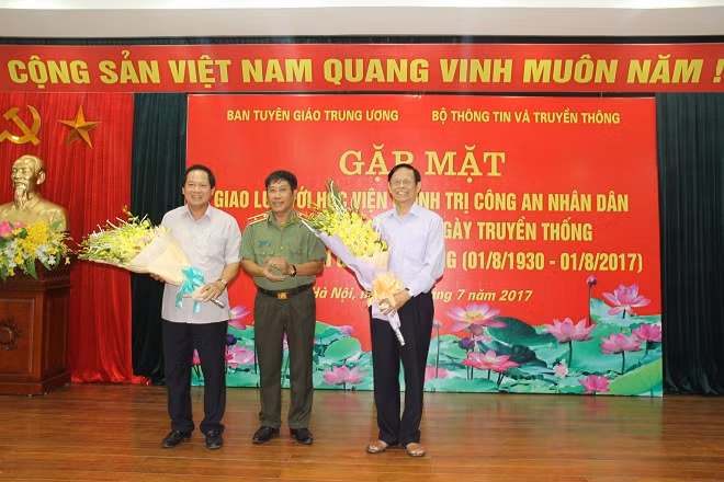 Thiếu tướng Trương Giang Long tặng hoa đồng chí Trương Minh Tuấn và đồng chí Nguyễn Hồng Vinh, nguyên Phó trưởng Ban Thường trực Ban Tuyên giáo Trung ương.