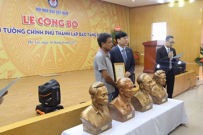 Đồng chí Hồ Quang Lợi trao giấy chứng nhận tiếp nhận hiện vật 4 bức tượng bằng đồng của chân dung 4 nhà báo liệt sĩ.