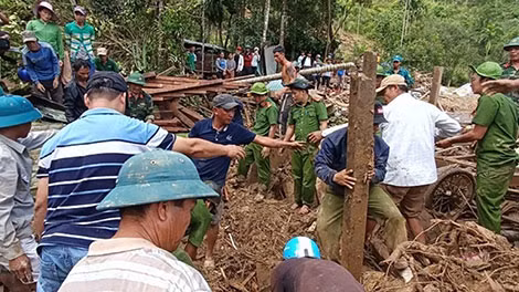 Lực lượng chức năng tìm kiếm người bị nạn dưới những ngôi nhà bị chôn vùi trong đống đổ nát do sạt lở đất.