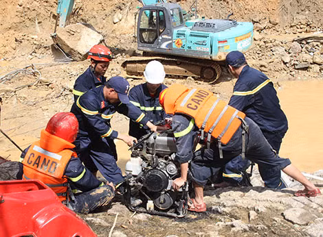 Thượng tá Trần Văn Lâu và Đại úy Lê Văn Kỳ (đứng góc trái) sửa chữa máy bơm hút nước ở lòng sông Rào Trăng.