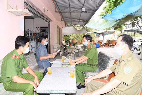Công an xã chính quy tuyên truyền tại nhà dân, phát động phong trào toàn dân bảo vệ an ninh Tổ quốc. Ảnh: Hồ Giang.