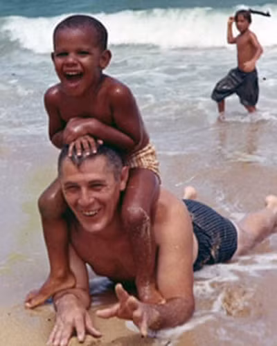 Cậu bé Barack Obama thời thơ ấu cùng ông nội chơi đùa trên bãi biển.