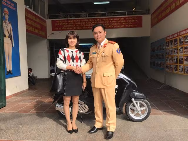 Chị Nguyễn Thị Hương nhận lại xe từ Đại úy Nguyễn Tuấn Cường, Phó Đội trưởng Đội CSGT số 2.