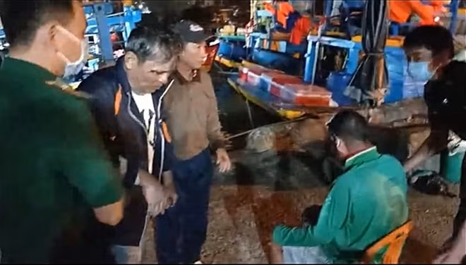 Cán bộ - chiến sĩ Đồn biên phòng Thanh Hải tiếp nhận hai nạn nhân may mắn sống sót được tàu cá BTh-98972 TS cứu vớt, đưa về cảng Phan Thiết. Ảnh : BĐBP Bình Thuận