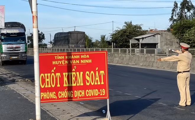 CSGT phối hợp kiểm soát dịch COVID-19 các chuyến vận hành trên đường quốc lộ 1A tại cửa ngõ phía Bắc Khánh Hòa ở xã Vạn Thọ, huyện Vạn Ninh. Ảnh : Hữu Toàn.