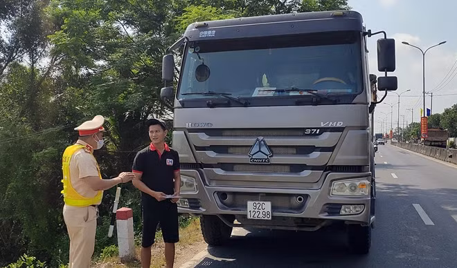 Cán bộ Trạm CSGT Thăng Bình kiểm tra hành chính xe tải ben lưu thông trên QL1A.
