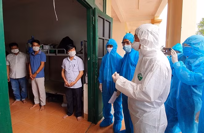 Ông Lê Trí Thanh (áo bảo hộ trắng) và lãnh đạo Sở Y tế thăm hỏi, động viên bà con Quảng Nam về từ TP Hồ Chí Minh.