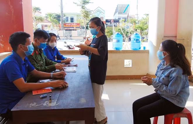 Công an xã Bình Triều, huyện Thăng Bình hỗ trợ người dân bốc số thứ tự khi đi làm CCCD.