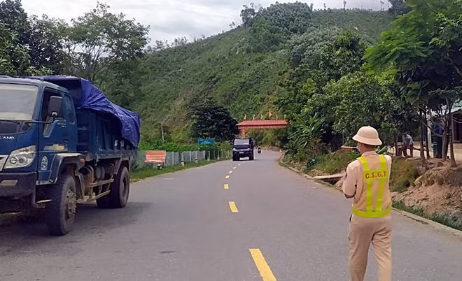 Cán bộ CSGT làm nhiệm vụ tại chốt kiểm soát trên đường Hồ Chí Minh tại xã A Vương, huyện Tây Giang ra hiệu lệnh dừng xe kiểm tra y tế.
