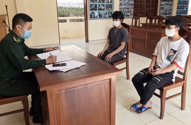 Lực lượng chức năng làm việc với 2 người vượt biên trái phép. Ảnh: H.A
