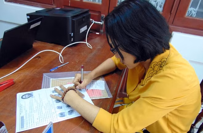 Sau khi kiểm tra, chị Trinh ký tên vào phiếu thu nhận thông tin CCCD.