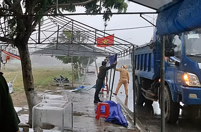 Lực lượng Công an làm nhiệm vụ tại chốt kiểm soát dịch cố giữ các trụ lán trại để không bị ngã đổ do mưa gió lớn.