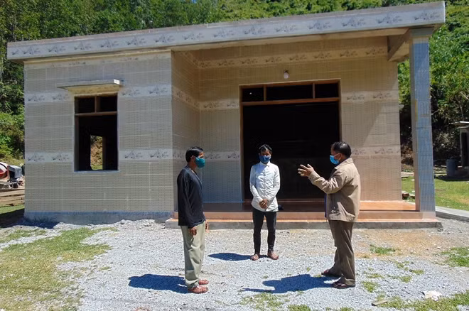 Lãnh đạo UBND xã Cà Dy (phải) thăm, động viên 2 anh em Alăng Dương và Alăng Giới tại nơi ở mới.
