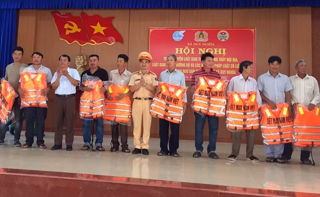 Lãnh đạo Phòng Cảnh sát đường thủy Công an tỉnh Quảng Nam trao áo phao tặng người dân xã Duy Nghĩa.