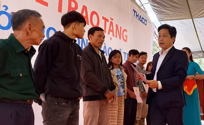 Ông Trần Duy Dũng, Chủ tịch UBND huyện Nam Trà My, bàn giao giấy tờ nhà mới cho người dân nóc Ông Đề. Ảnh: CTV