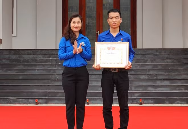 Bí thư Tỉnh đoàn Quảng Nam Phạm Thị Thanh trao Bằng khen cho anh Trần Văn Tròn.