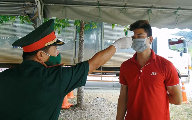 Tiến hành đo thân nhiệt cho người dân tại chốt kiểm soát dịch COVID-19 khu vực đèo Lò Xo.