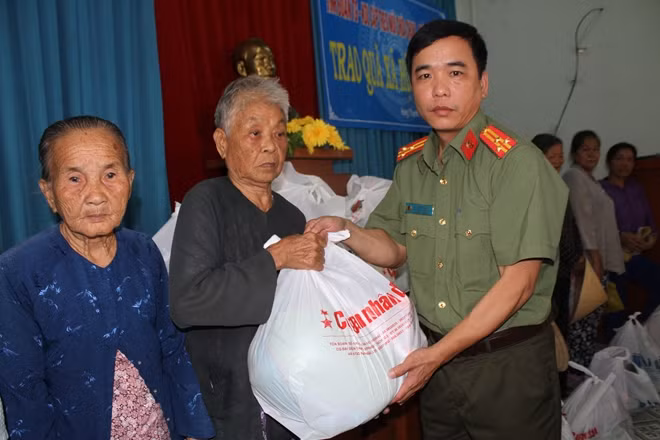 Thượng tá Ung Văn Quang, Trưởng phòng Công tác Chính trị - Công tác Đảng Công an Tiền Giang trao quà cho người dân nghèo tại xã Hưng Thạnh, huyện Tân Phước, tỉnh Tiền Giang