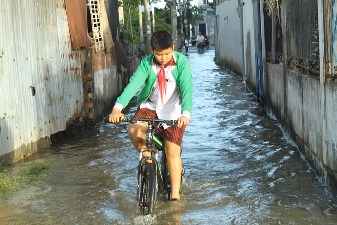 Thủy triều dâng cao vào giờ tan học khiến các em học sinh gặp khó khăn khi phải di chuyển về nhà
