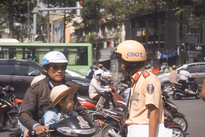 CSGT nhắc nhở phụ huynh về lỗi vi phạm không đội mũ bảo hiểm cho trẻ em