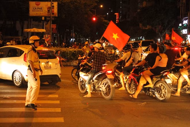 Cầm cờ chạy xung quanh các tuyến đường, hò reo thể hiện vui mừng của các CĐV đội tuyển Việt Nam