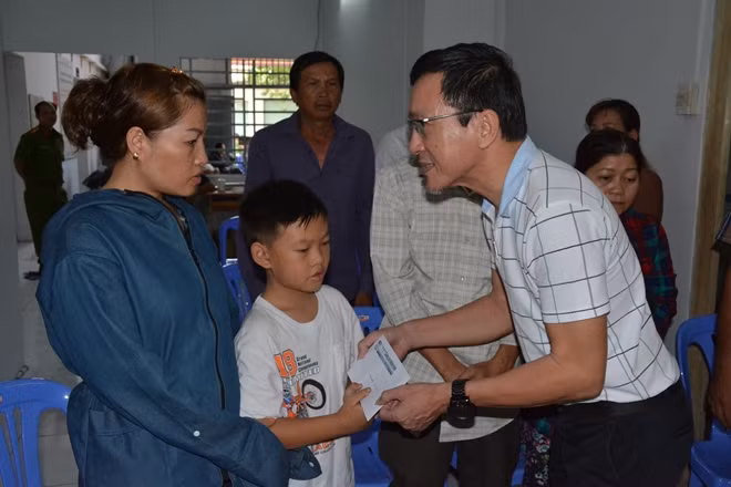 Ông Lâm Tấn Lợi - Giám đốc công ty Võng xếp Duy Lợi trao tiền hỗ trợ cho vợ hiệp sĩ Nguyễn Văn Thôi đã tử nạn trong vụ bắt nhóm cướp xe SH và tối ngày 13-5