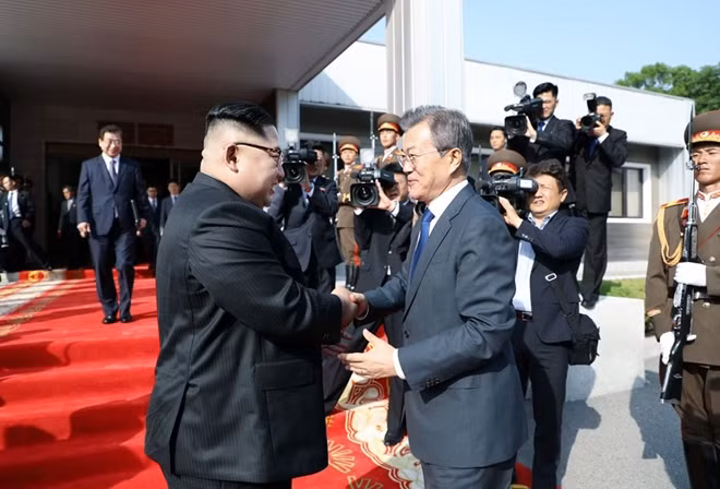 Chủ tịch Kim và Tổng thống Moon bắt tay nhau trước tòa nhà Tongilgak. Ảnh: KCNA