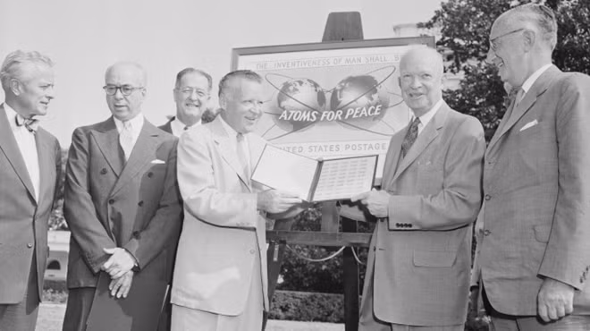 Tổng thống Mỹ Eisenhower (phải) nhận tem kỷ niệm vinh danh Chương trình "Nguyên tử vì Hòa bình" của ông. Ảnh: History
