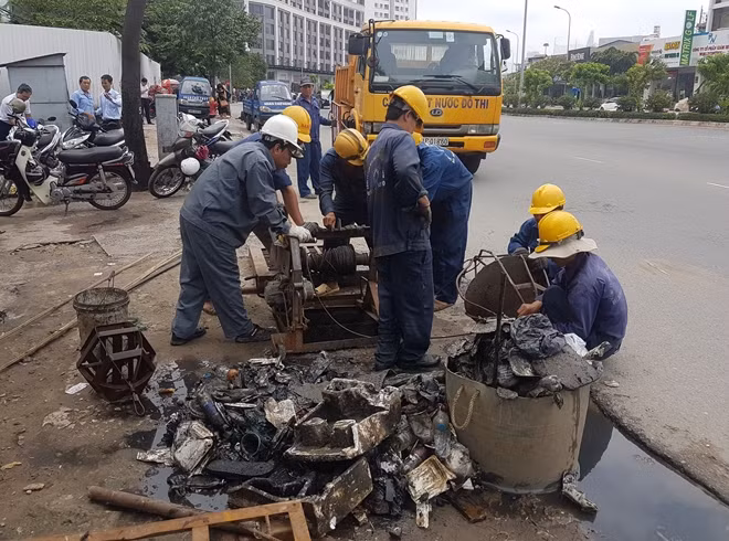 Công nhân thoát nước đô thị móc rác từ cống thoát nước ngày 18-10.