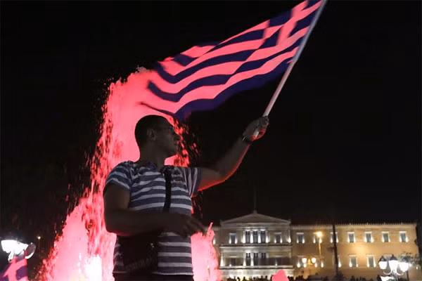 Người dân Hy Lạp ăn mừng sau khi kết quả kiểm phiếu sơ bộ được công bố. (Ảnh: Reuters).