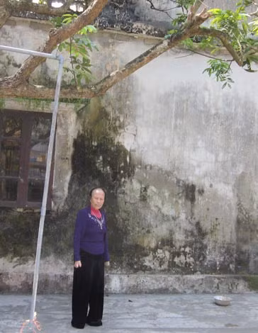 Bà Hằng bên ngôi nhà hai tầng xây dựng năm 1996.
